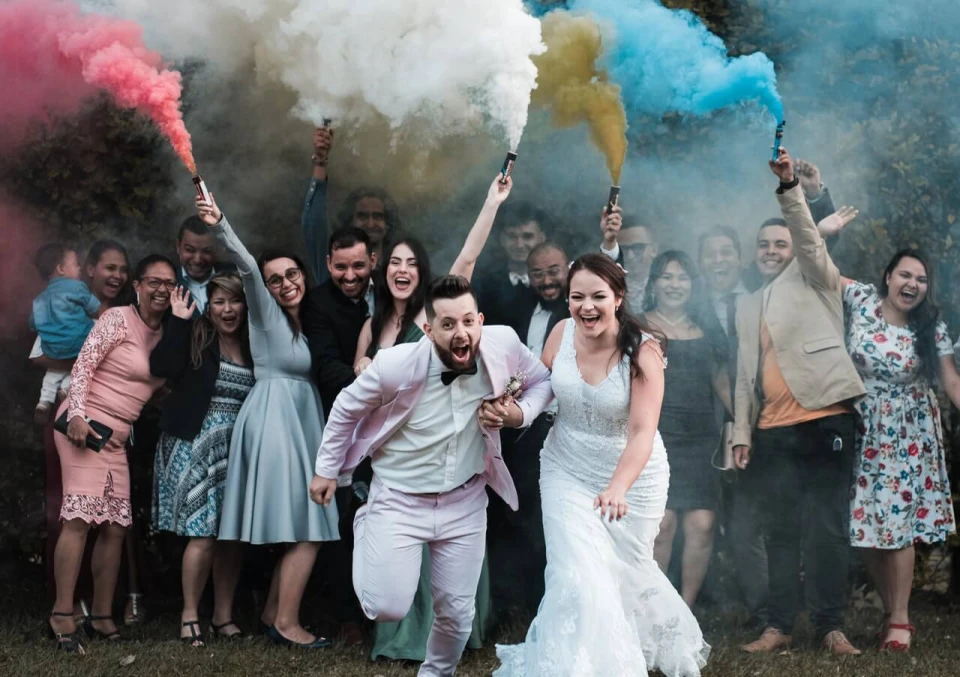 Mensen vieren feest buiten met kleurrijke rook en lachende gezichten, perfect voor een levendig event met photobooth.