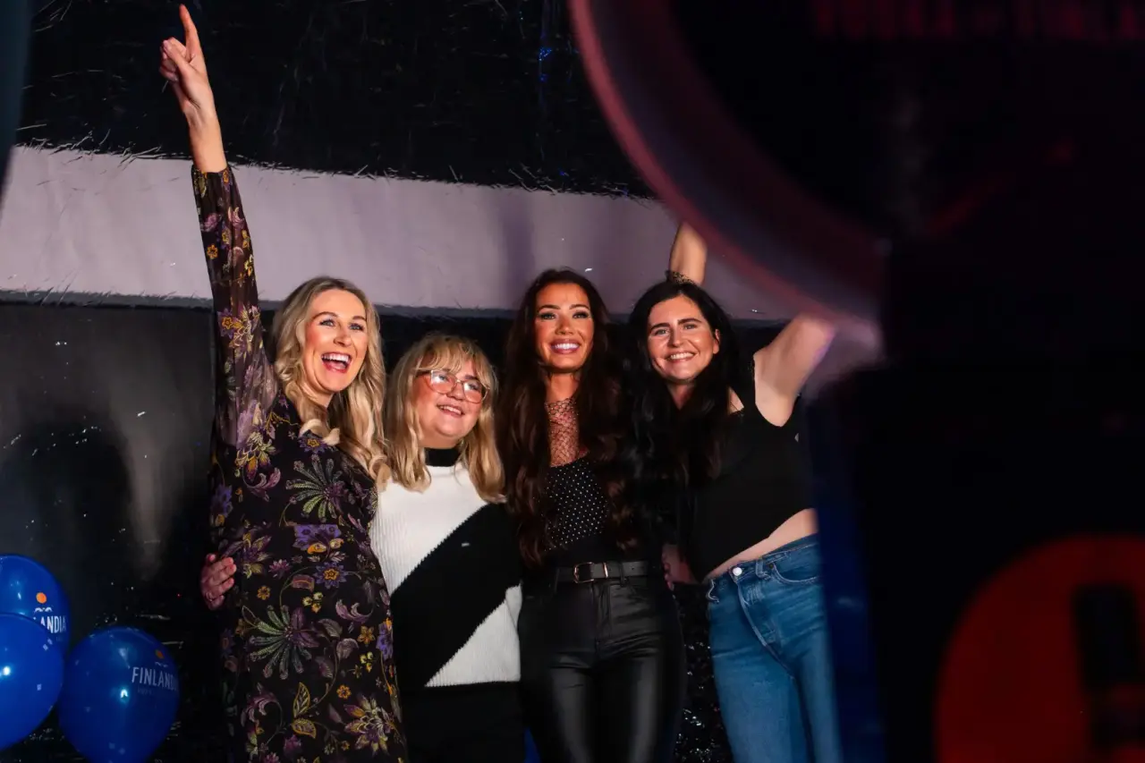 Vriendengroep maakt foto's met neonlicht-achtergrond bij een ronde photobooth.