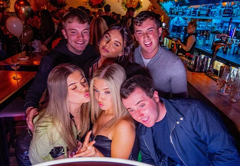 Gasten met neonlicht op de achtergrond maken plezier bij een photobooth op een dansfeest.